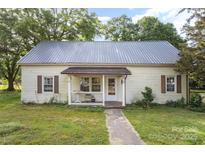 Quaint one-story home featuring a metal roof, small front porch, and lawn at 1221 Patterson St, Shelby, NC 28152
