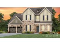 Charming two-story home boasts a stone and siding exterior, complemented by a well-manicured lawn and a two-car garage at 2204 Riverbend Ave # 20, Monroe, NC 28110
