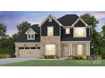 Charming two-story home featuring a stone and dark siding exterior, attached two-car garage, and landscaped front yard at 2214 Riverbend Ave # 22, Monroe, NC 28110