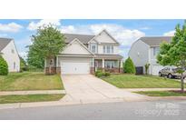 Charming two-story home with manicured lawn, stone accents, and a two-car garage at 306 Fesperman Cir, Troutman, NC 28166
