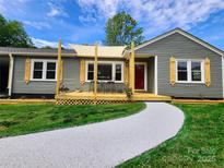 Charming one-story home with a welcoming front porch and a freshly painted walkway at 501 N Hawthorne St, Mount Holly, NC 28120