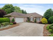 Charming brick home with manicured landscaping, a two-car garage, and a spacious driveway at 7471 Barfield Ln, Denver, NC 28037