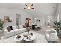 Bright living room boasts modern furniture, decor, and an open floor plan to the dining area, perfect for entertaining at 8313 Carob Tree Ln, Charlotte, NC 28215