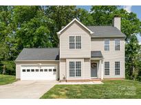 Charming two-story home featuring a two-car garage, well-kept lawn, and beautiful green trees in the background at 8509 Sienna Dr, Charlotte, NC 28215
