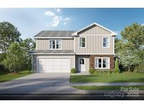 Charming two-story home with stone accents, attached garage, and a well-manicured lawn at Lot 3 Henderson Cir, Harrisburg, NC 28075
