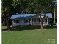 Charming single-story home with a blue metal roof and a well-manicured lawn at , Salisbury, NC 28147