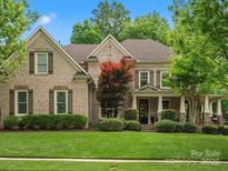 Charming brick home featuring well-manicured landscaping, inviting curb appeal, and traditional architectural details at 1030 Westbury Dr, Matthews, NC 28104