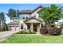 Charming two-story home with a welcoming front porch, manicured lawn, and well-kept landscaping at 106 Sweet Briar Dr, Fort Mill, SC 29707