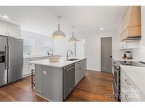 Bright kitchen features a central island with sink, stainless steel appliances, and white cabinets at 1314 Ordermore Ave, Charlotte, NC 28203