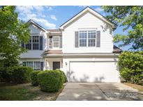 Charming two-story home with a two-car garage, manicured bushes, and dark shutters at 14311 Riding Hill Ave, Charlotte, NC 28213