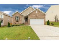 Charming brick home with a well-manicured lawn and attached two-car garage on a sunny day at 1680 Beleek Ridge Ln, Clover, SC 29710