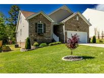 Beautiful brick home featuring lush front yard, manicured landscaping, and an attached garage at 1680 Beleek Ridge Ln, Clover, SC 29710
