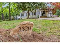 Charming single-story home featuring a stone address marker and a beautifully landscaped front yard at 3320 Eastwood Dr, Charlotte, NC 28205