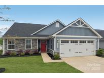Charming single-Gathering home with gray siding, stone accents, attached garage, and manicured lawn at 4205 Jones Creek Ln, Charlotte, NC 28215