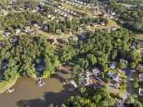 Expansive aerial view of a charming neighborhood nestled among lush trees, some homes with lake access and private docks at 444 Snapdragon Dr, Clover, SC 29710