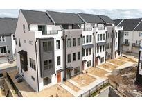 Modern townhome complex with white and gray exteriors, balconies, and well-defined landscaping at 6009 Countess Dr # 50, Charlotte, NC 28217