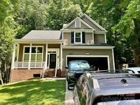 Charming two-story home with a covered front porch, attached garage and well-maintained lawn at 7401 Kinsmore Ln, Charlotte, NC 28269