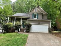 Charming two-story home with a well-maintained lawn, a covered porch and a large attached garage at 7401 Kinsmore Ln, Charlotte, NC 28269