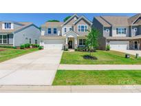 Charming two-story home boasts stone accents, manicured lawn, and attached two car garage at 115 Haddonsfield Dr, Mooresville, NC 28115