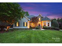 Charming two-story home with manicured lawn and stone accents, beautifully lit at dusk at 18730 Floyd Ct, Davidson, NC 28036