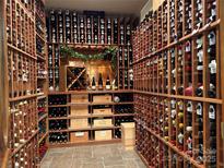 Spacious wine cellar with wooden racks storing numerous bottles of wine on tile floor at 18730 Floyd Ct, Davidson, NC 28036
