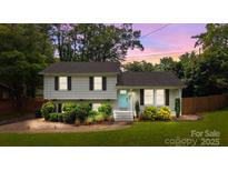 Charming split-level home with a light blue front door, beautiful landscaping, and a cozy feel at 2100 Shadyview Dr, Charlotte, NC 28210