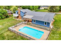 Aerial view of blue house featuring a swimming pool, large yard, and deck at 2649 Tiffany St, Conover, NC 28613