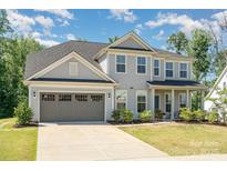 Charming two-story home with a gray exterior, two-car garage, landscaped yard, and inviting front porch at 3925 Tokay Ln, Fort Mill, SC 29707