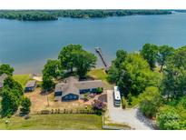 Beautiful waterfront home with a private dock and lush green surroundings on a sunny day at 5200 Masons Ferry Rd, Clover, SC 29710
