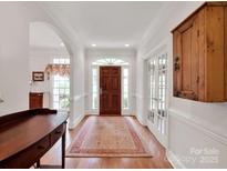 Inviting foyer with hardwood floors, arched doorways, and elegant details at 7716 Seton House Ln, Charlotte, NC 28277