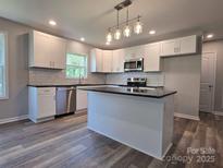 Stylish kitchen features white cabinets, black countertops, subway tile backsplash, and stainless steel appliances at 901 3Rd St, Spencer, NC 28159