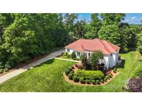 Stunning home with a red roof, lush landscaping, and a circular driveway at 1004 Berwick Ct, Waxhaw, NC 28173