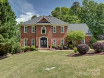 Beautiful red brick home featuring a manicured front lawn and classic architectural details at 15824 Feeny Ct, Charlotte, NC 28278