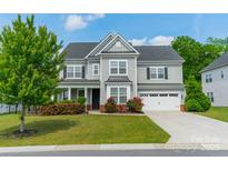 Charming two-story home features a manicured lawn and an attached two-car garage at 2164 Hanging Rock Rd, Fort Mill, SC 29715