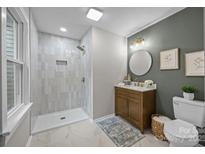 Stylish bathroom featuring a walk-in shower, updated vanity, decorative lighting, and neutral paint palette at 322 Corriher Heights Ave, China Grove, NC 28023