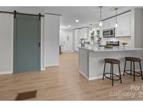 Bright kitchen features white cabinets, quartz countertops, breakfast bar, and stainless steel appliances at 322 Corriher Heights Ave, China Grove, NC 28023