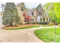 Beautiful home exterior with stone accents, lush landscaping, and a curved walkway at 3400 Baucom Manor Rd, Monroe, NC 28110