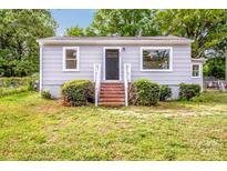 Charming single story home with a black front door, brick steps, and gray siding, and front bushes at 444 Oakwood Ave, Mooresville, NC 28115