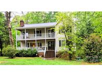 Charming two-story home with a double porch and lush landscaping, perfect for relaxing and enjoying the outdoors at 552 Blue Rock Dr, Charlotte, NC 28213