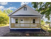 Charming home featuring a welcoming front porch with wood railing and a light-colored exterior under a clear blue sky at 555 Pryor St, Chester, SC 29706