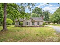 Charming single-story home with neutral siding, black shutters, a covered carport, and a well-manicured lawn at 604 Chaney Rd, Monroe, NC 28110