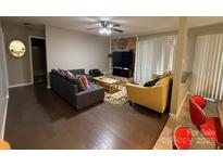 Comfortable living room with ceiling fan, brick accent wall, and sliding glass door access to the outdoors at 11106 Harrowfield Rd, Charlotte, NC 28226
