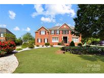Beautiful red brick home with manicured front yard and landscaping on a bright day at 11917 Chevis Ct, Charlotte, NC 28277