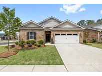 Inviting brick home featuring a well-manicured lawn, an attached two-car garage, and lovely landscaping at 12705 Twilight Dr, Mint Hill, NC 28227