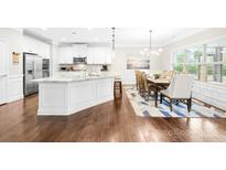 Bright, open kitchen features a large island, stainless steel appliances, and a breakfast nook with natural light at 15702 Guthrie Dr, Huntersville, NC 28078
