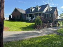 Charming brick home featuring a welcoming front porch and well-manicured lawn, creating a classic and inviting curb appeal at 181 Edgewater Rd, Hickory, NC 28601