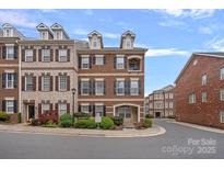 Charming brick townhome with dormer windows and manicured landscaping on a tree-lined street at 1948 Winpole Ln, Charlotte, NC 28273
