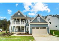 Charming two-story home with a blue exterior, covered porch, two-car garage, and well-manicured lawn at 2028 Cedar Falls Dr # 10, Waxhaw, NC 28173