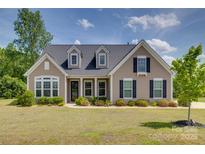 Charming one story home featuring manicured lawn, dormer windows, neutral siding, and contrasting black shutters at 4211 Maggie Springs Way, Clover, SC 29710