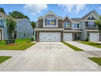 Charming townhome with stone accents, a two-car garage, and well-manicured lawn at 4254 Black Ct # 231, Harrisburg, NC 28075